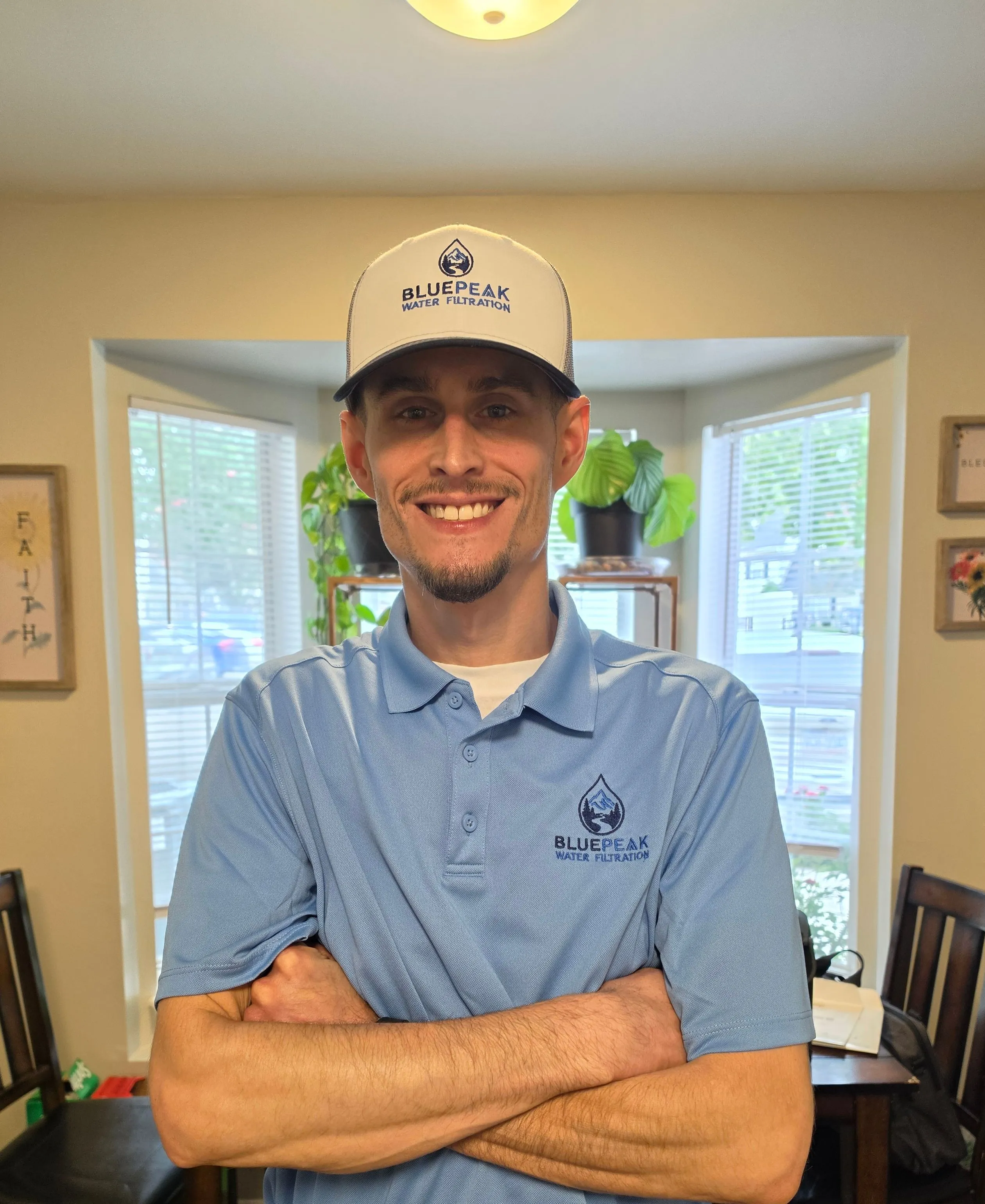 Branden, the owner of BluePeak Water Filtration, in a BluePeak polo and cap.